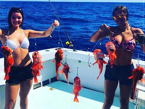 Two anglers holding multi-hook rigs of deep drop snappers aboard Spellbound, Miami