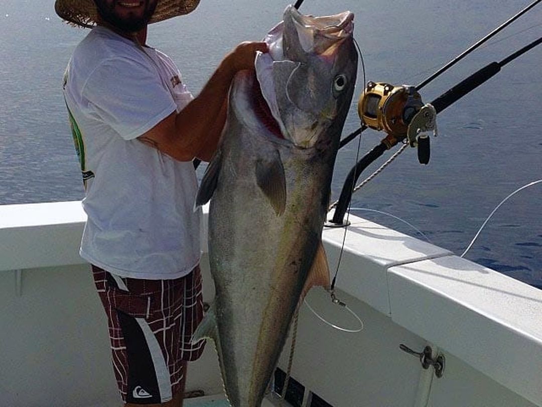 Angler with an amberjack caught aboard Spellbound, Miami