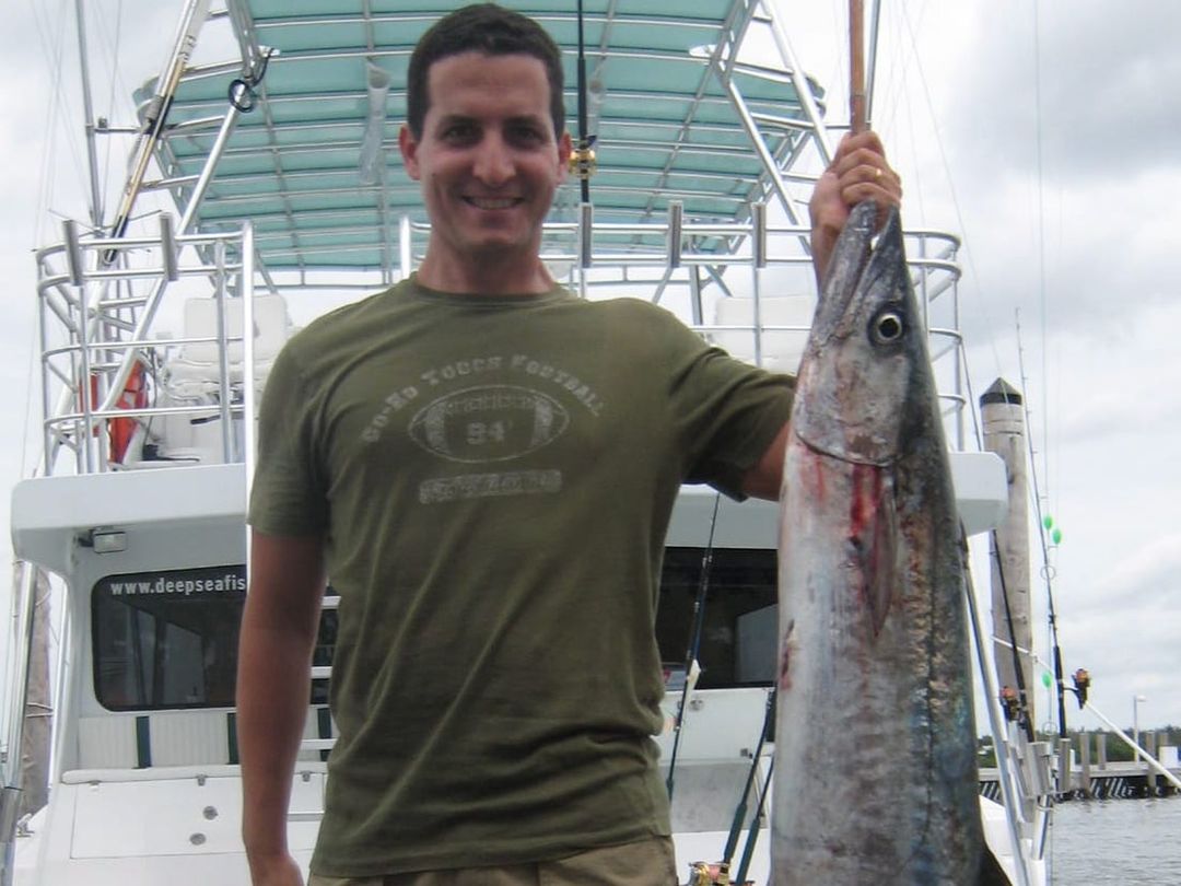 Angler with a kingfish caught aboard Spellbound, Miami