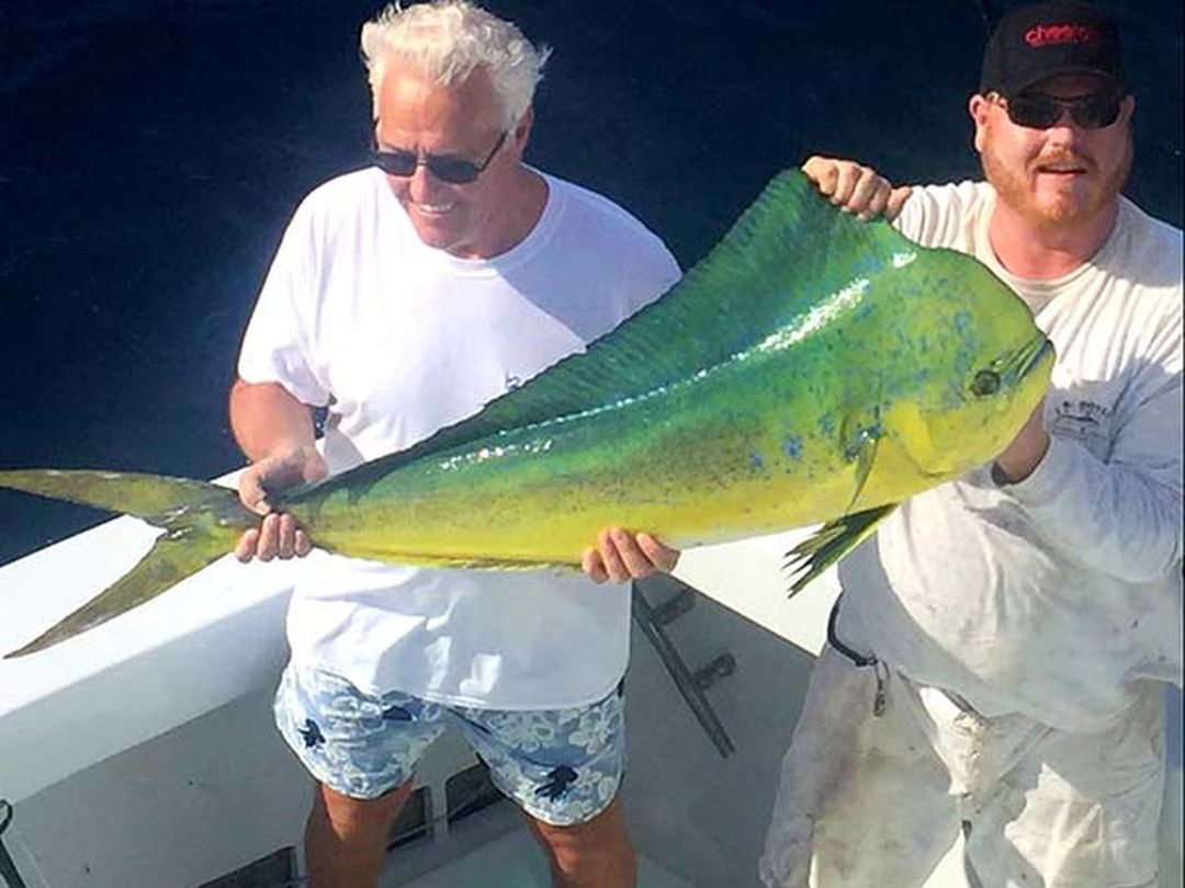 Two anglers with a bull mahi mahi caught aboard Spellbound, Miami