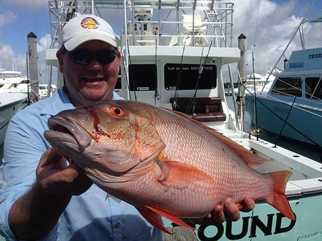 Angler with a mutton snapper caught aboard Spellbound, Miami