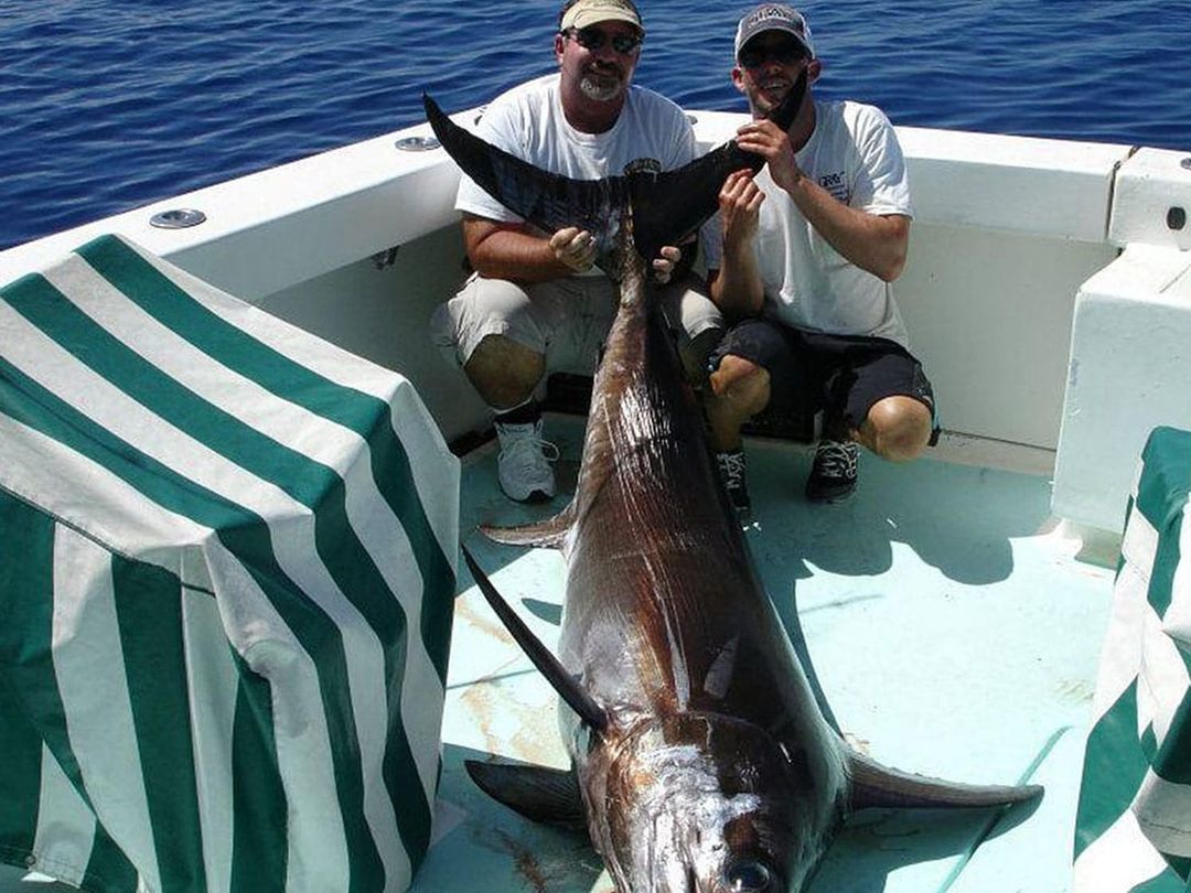 Anglers with a swordfish caught aboard Spellbound, Miami