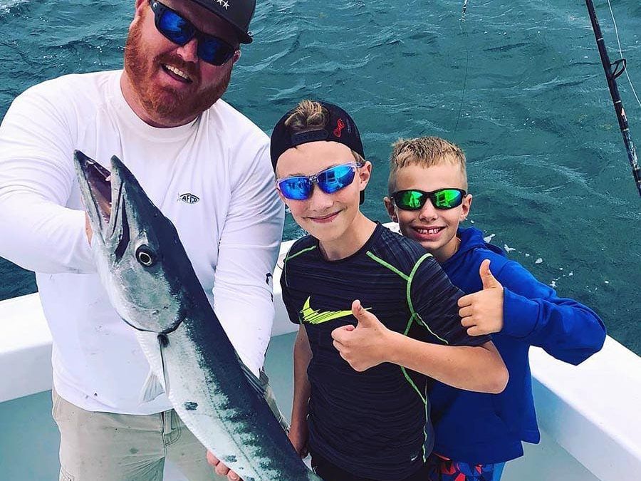 Dad and two kids with a barracuda aboard Spellbound