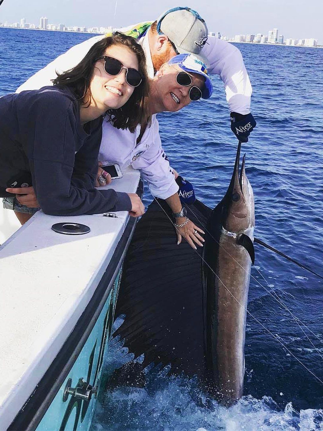 Anglers with a sailfish boatside while kitefishing off Miami