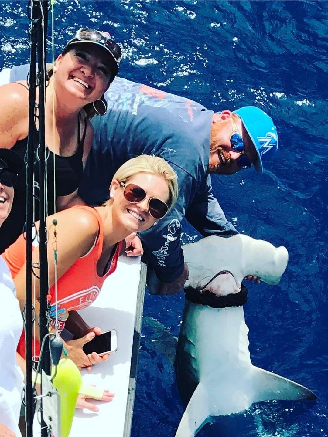 Anglers with a hammerhead shark boatside over the wrecks off Miami
